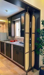 a kitchen with black cabinets and a large counter top at سديم الفجر للنزل السياحية بيوت عطلات وشاليهات - فئه اقتصادى in Taif +16 photos