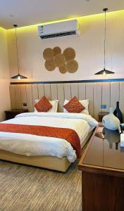 a hotel room with a large bed and a table at سديم الفجر للنزل السياحية بيوت عطلات وشاليهات - فئه اقتصادى in Taif