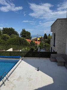a swimming pool next to a building with a building at Aqua Azzuro Lovran in Lovran
