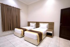 a bedroom with two beds and a window in it at شقق شاطئ الواحة in Jeddah