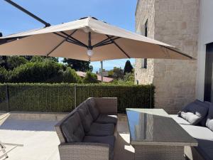 a patio with a table and an umbrella at Aqua Azzuro Lovran in Lovran