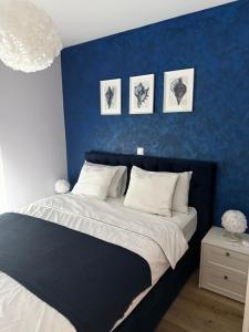 a bed in a bedroom with a blue wall at Aqua Azzuro Lovran in Lovran