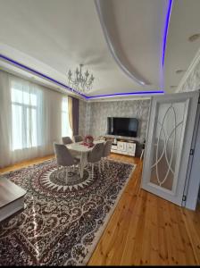 a living room with a table and chairs and a television at Qebele gunluk ev in Bum