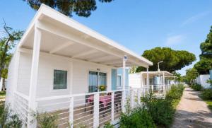 a white house with awning on the porch at Camping Pineta - Nikoli Tour in Cesenatico