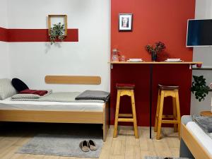 a room with a bed and a counter with two stools at 'MONAS' mini apartments in Sombor
