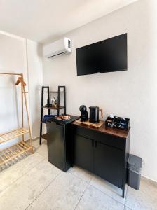 a room with a counter with a tv on the wall at VR-Room in Forte Village