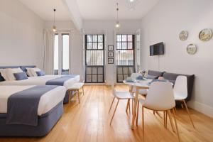 a bedroom with two beds and a table and chairs at Mouzinho 244 - Porto Houses & Suites in Porto