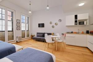 a room with two beds and a kitchen with a table at Mouzinho 244 - Porto Houses & Suites in Porto