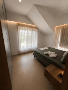 a bedroom with a bed with two towels on it at Villa Krasta in Elbasan +27 photos