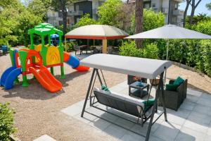 a playground with a slide and an umbrella at Residence Casa Pineta in Principina a Mare