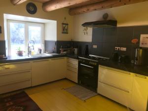 a kitchen with black and white appliances and a window at Ferme de Chaudeyrac in Saint-Front +9 photos