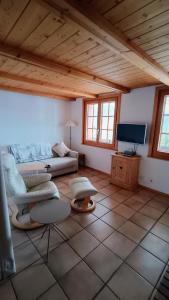 a living room with a couch and a tv at El Balcón des Diablerets in Les Diablerets