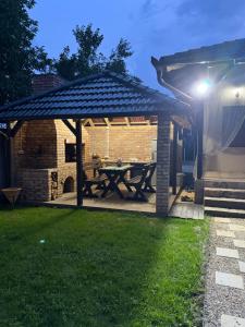 a wooden picnic table under a gazebo at Tri topole Brioni in Kočino Selo