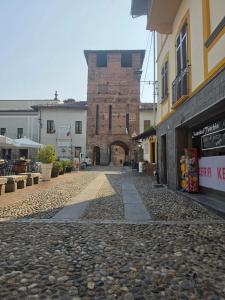 a cobblestone street in a town with a brick building at Porta Del Ricetto in Candelo