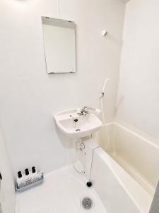 a white bathroom with a sink and a bath tub at Stay min NAKAMURA in Nagoya +14 photos
