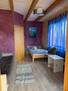 a room with a bed and a couch and a table at Viesu māja Liepas in Rēzekne
