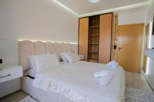 a bedroom with a white bed with two towels on it at flora bay luxe in Agadir +2 photos