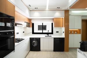 a kitchen with white cabinets and a black dishwasher at flora bay luxe in Agadir