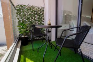 a small table and chairs on a balcony with green grass at flora bay luxe in Agadir