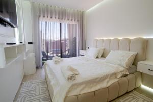 a white bedroom with a large bed with towels on it at flora bay luxe in Agadir