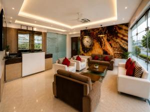a living room with couches and a clock on the wall at Hotel Vrindavan Sultanpur in Sultānpur