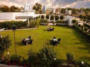 a large grassy yard with lounge chairs on it at Hotel Vrindavan Sultanpur in Sultānpur