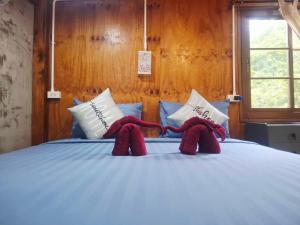 two stuffed animals are sitting on a bed at NO name bangalow in Ko Lanta Yai