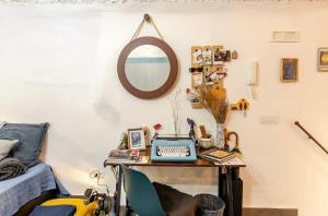 a desk with a computer and a mirror in a room at Casa Velata a Spaccanapoli in Naples
