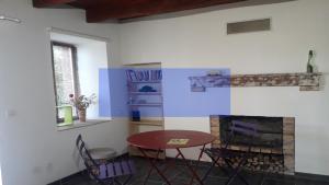 a living room with a table and a fireplace at Odyssée auvergne in Vallon-en-Sully +4 photos
