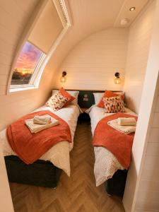 two beds in a small room with a window at Leisure Lodges in Glastonbury