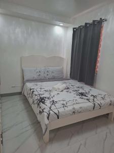 a bed in a white room with a bedspread with flowers at Compostela Two Story Richwood Townhome Breakfast Offered in Compostela