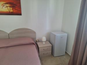 a bedroom with a bed and a small refrigerator at Da zia Sofia in Torre Lapillo