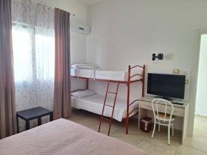 a bedroom with a bunk bed and a desk with a television at Da zia Sofia in Torre Lapillo