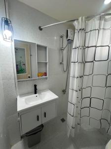 a bathroom with a sink and a shower curtain at Compostela Two Story Richwood Townhome Breakfast Offered in Compostela +30 photos