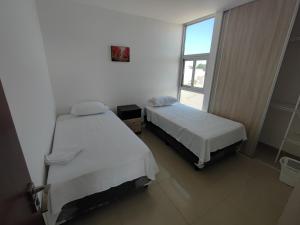 two beds in a room with a window at Atlantis Tower in Santa Cruz de la Sierra