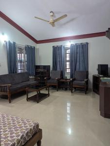 a living room with furniture and a ceiling fan at Coorg homes in Madikeri