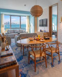 a living room with a table and a couch at Symphony Style Hotel Kuwait in Kuwait