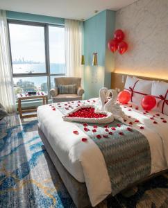 a bedroom with a bed with red roses and two swans at Symphony Style Hotel Kuwait in Kuwait +269 photos