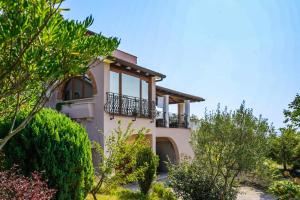 a house with a balcony and trees at Apartment Elio 1606 in Labin