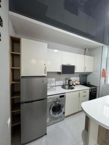 a kitchen with a refrigerator and a washing machine at Ideal home in Minda