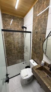 a bathroom with a toilet and a glass shower at Flat - Para quem busca tranquilidade e conforto in Goiânia