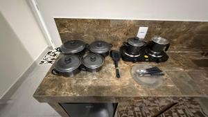 a stove top with pots and pans on a counter at Flat - Para quem busca tranquilidade e conforto in Goiânia