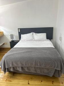 a bedroom with a large bed with a blue headboard at Hotel HILLMON in Sosúa