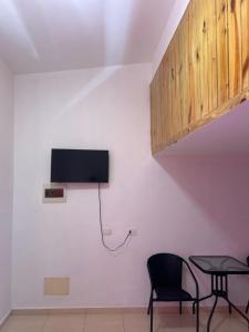a room with two chairs and a tv on a wall at Hotel HILLMON in Sosúa