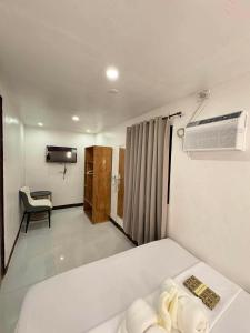 a hotel room with a bed and a air conditioner at Camila Hostel Coron in Coron