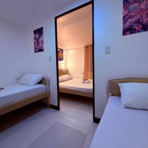 a mirror in a room with two beds at Camila Hostel Coron in Coron