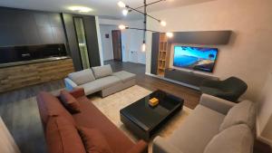 a living room with a couch and a flat screen tv at Pines Apartment in Kosovo Polje