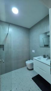 a white bathroom with a toilet and a sink at Pines Apartment in Kosovo Polje +22 photos