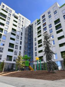 a playground in front of a large apartment building at Pines Apartment in Kosovo Polje