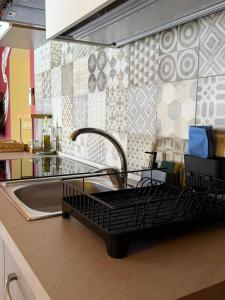 a kitchen sink with a dish drying rack next to it at Casa Vacanze Guccini in Porticello +10 photos